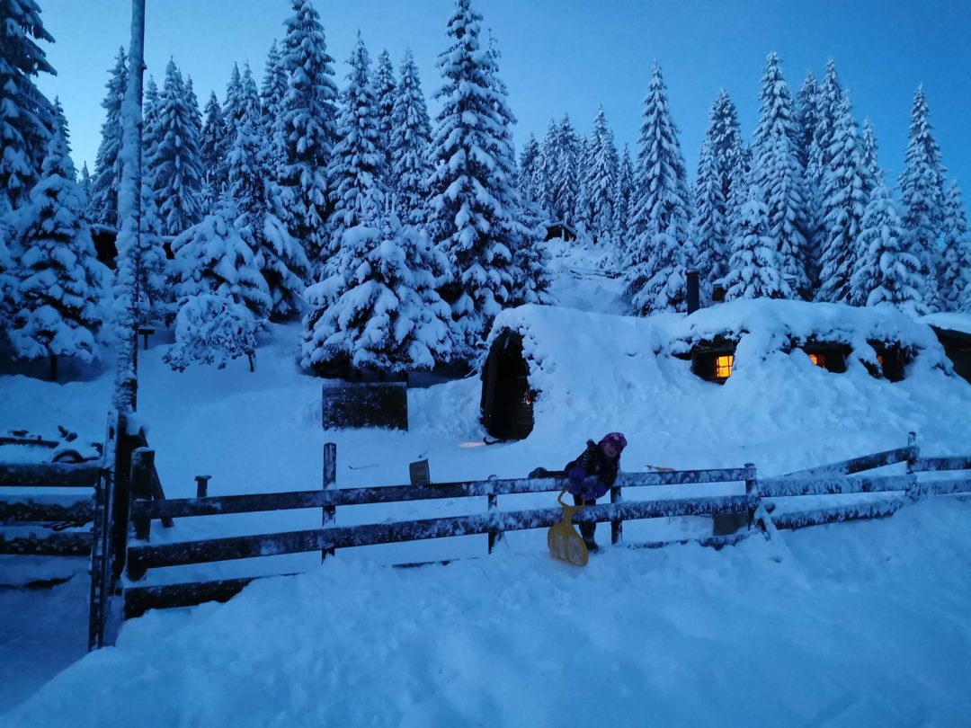 Gammen på Småtjern Naturbarnehage i snø, med lys i vinduene